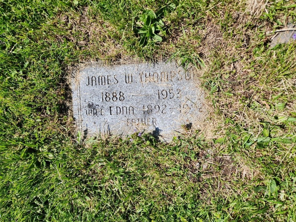 Flat marker covered in grass