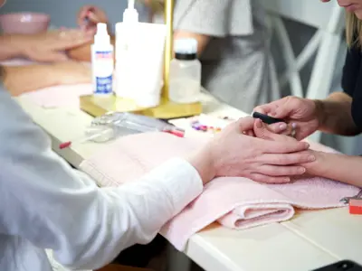 A person getting their nails done in a salon