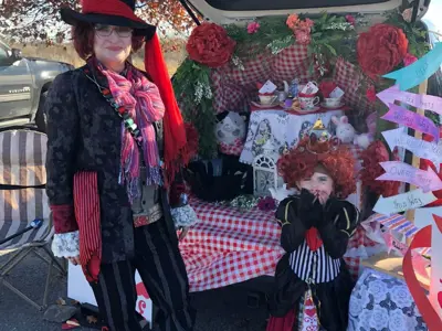 Two people dressed up in front of a car for the trunk or treating event