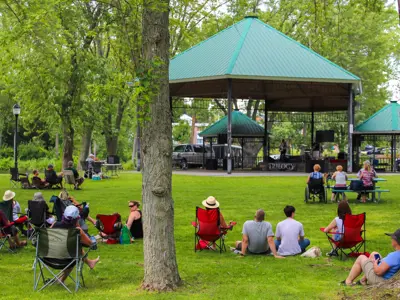 People in a park watching a band for Music By The River